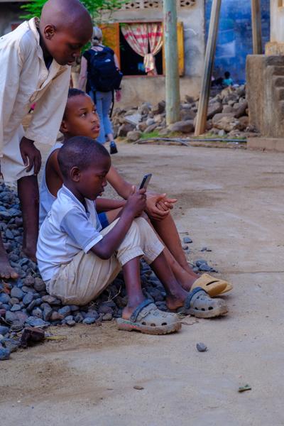 Children watching a smartphone on a street in Moroni, Comoros M'lédjélé, Comoros