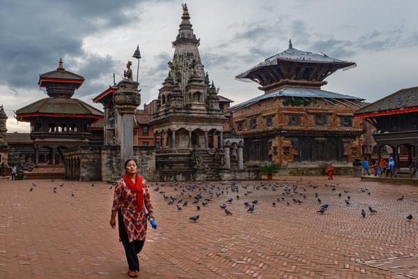 Historic Bhaktapur Durbar Square courtyard with a passerby and pigeons Bhaktapur, Nepal