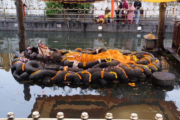 Coiled Serpent Sculpture Adorned with Marigolds at Temple Pool Budhanilkantha, Nepal