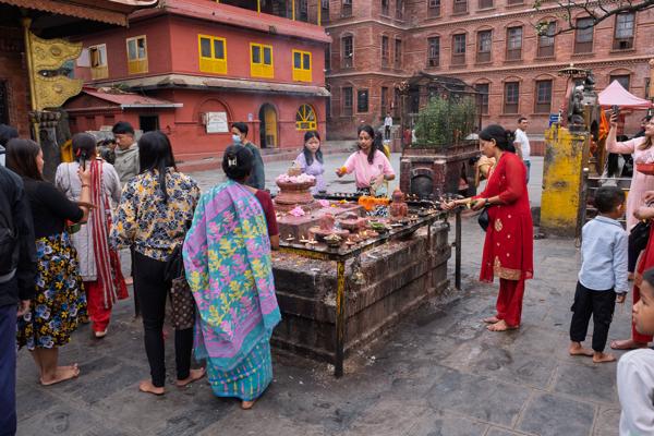 Devotees at an outdoor altar in a brick temple courtyard, Nepal Budhanilkantha, Nepal