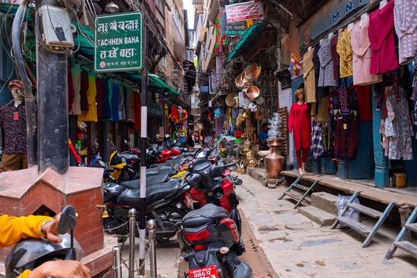 Narrow Nepali Street Market with Clothing Shops and Motorbikes Kathmandu Metropolitan, Nepal