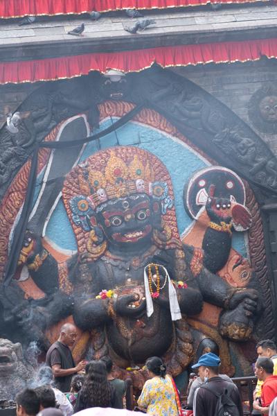 Devotees at a colossal guardian statue in a Nepalese temple Kathmandu Metropolitan, Nepal