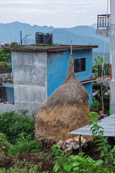 Hillside Village Scene with Conical Thatched Haystack and Blue House Aanbu Khaireni, Nepal