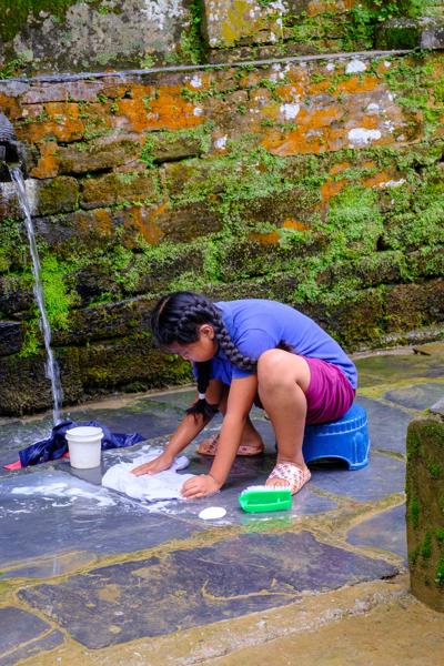 Girl Washing Clothes at a Mossy Stone Wall Bandipur, Nepal