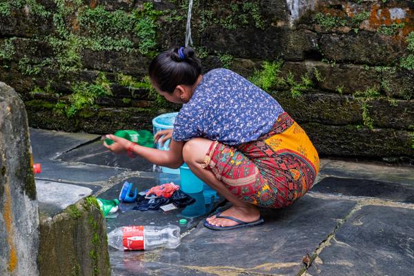 Woman Washing Clothes by a Mossy Stone Wall Bandipur, Nepal