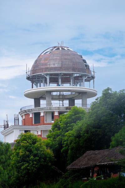 Abandoned observatory dome rising above lush greenery Bandipur, Nepal