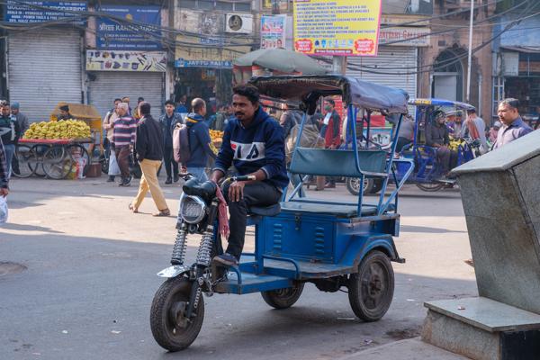 Electric rickshaw driver in Old Delhi market street Delhi, India