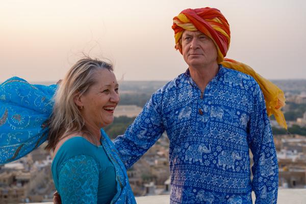 Couple in colorful Rajasthani attire overlooking Jaisalmer at sunset Jaisalmer, India
