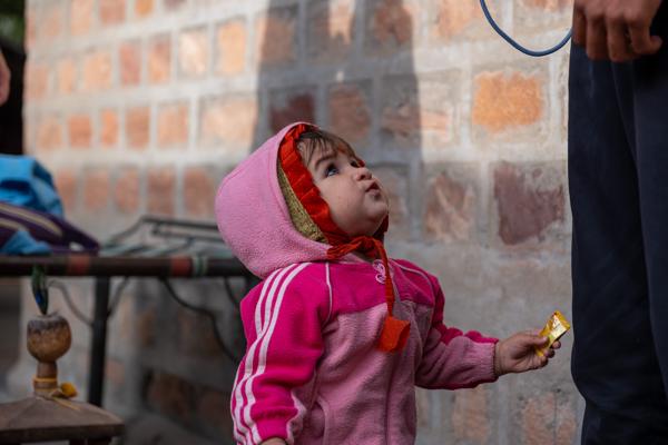 Toddler in Pink Hoodie Looking Up at an Adult in Jodhpur, India Luni Tehsil, India