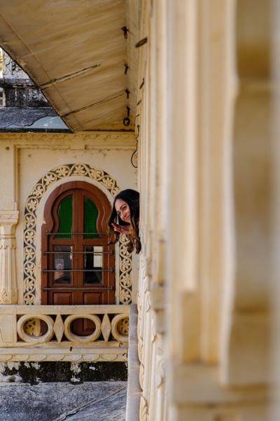 Woman Peeking from an Ornate Palace Balcony in Udaipur Udaipur, India
