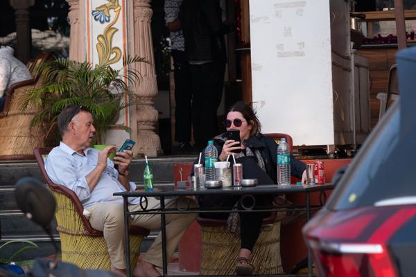 Tourists Using Phones at a Street Cafe in Pushkar, Rajasthan Pushkar, India