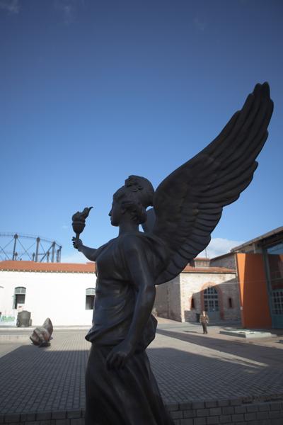 Winged Angel Sculpture in Athens Courtyard under Clear Sky Athens, Greece