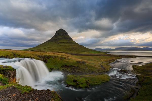 Kirkjufell with Cascading Waterfall under Moody Skies Grundarfjarðarbær, Iceland