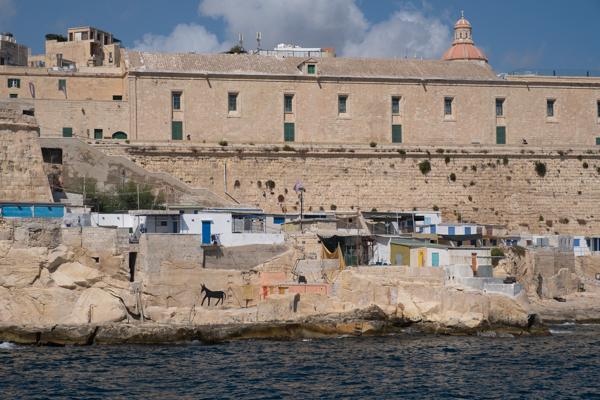 Limestone Harbor Wall and Seaside Huts in Valletta, Malta Valletta, Malta
