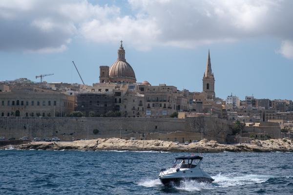 Valletta waterfront with motorboat and church dome Valletta, Malta