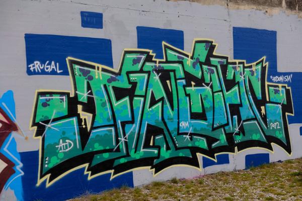 Vibrant Graffiti M mural on a concrete wall Bezirk Lebern, Switzerland